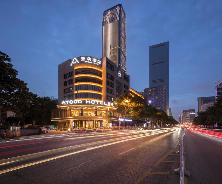 Atour Hotel Changsha IFC Center في تشانغشا: شارع المدينة في الليل مع مبنى