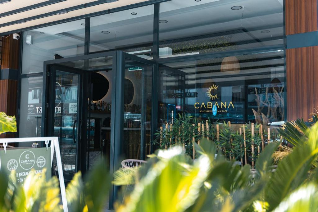 a restaurant with glass doors and plants in front of it at Cabana Boutique Hotel & Cafe in Milas