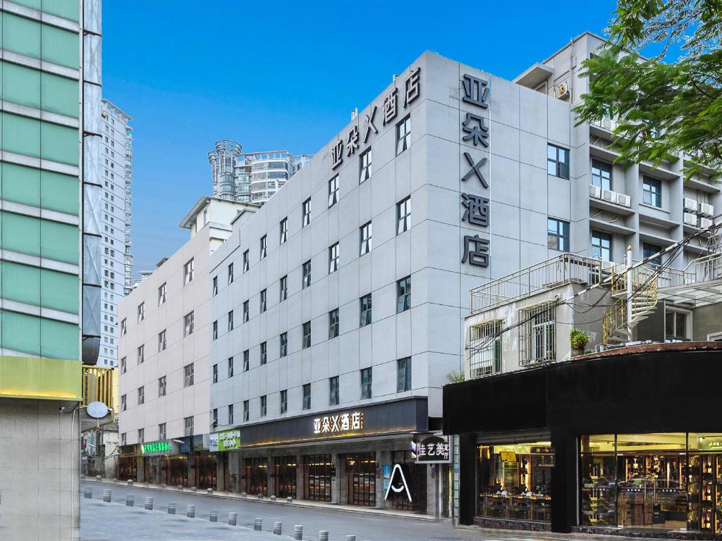 a large white building on a city street at Atour X Hotel Xiamen Zhongshan Road Ferry Wharf in Xiamen