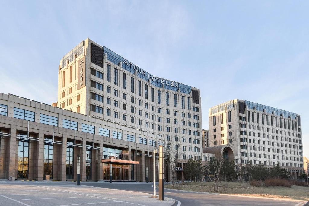 Deux grands bâtiments dans une ville avec un parking dans l'établissement Atour Hotel Beijing Linkong New International Exhibition Center, à Shunyi