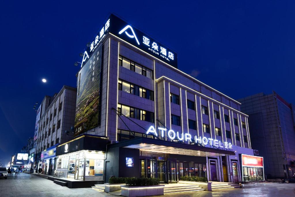 een gebouw met een bord erop bij Atour Hotel Dalian Development Zone Jinma Road in Dalian