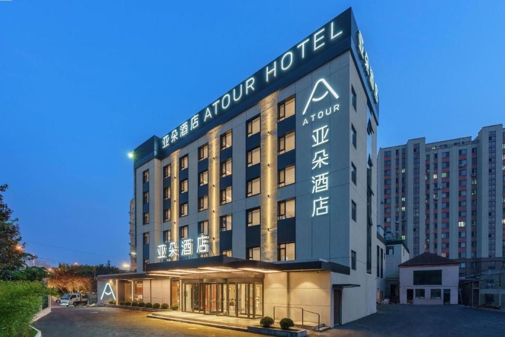 a hotel with a sign on the front of it at Atour Hotel Dalian Airport in Dalian