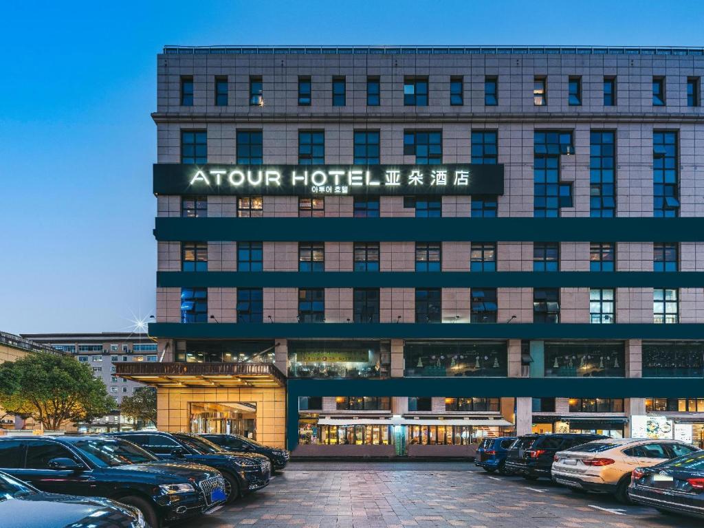 um edifício de hotel com carros estacionados em frente em Atour Hotel Shanghai Hongqiao Korea Street em Xangai