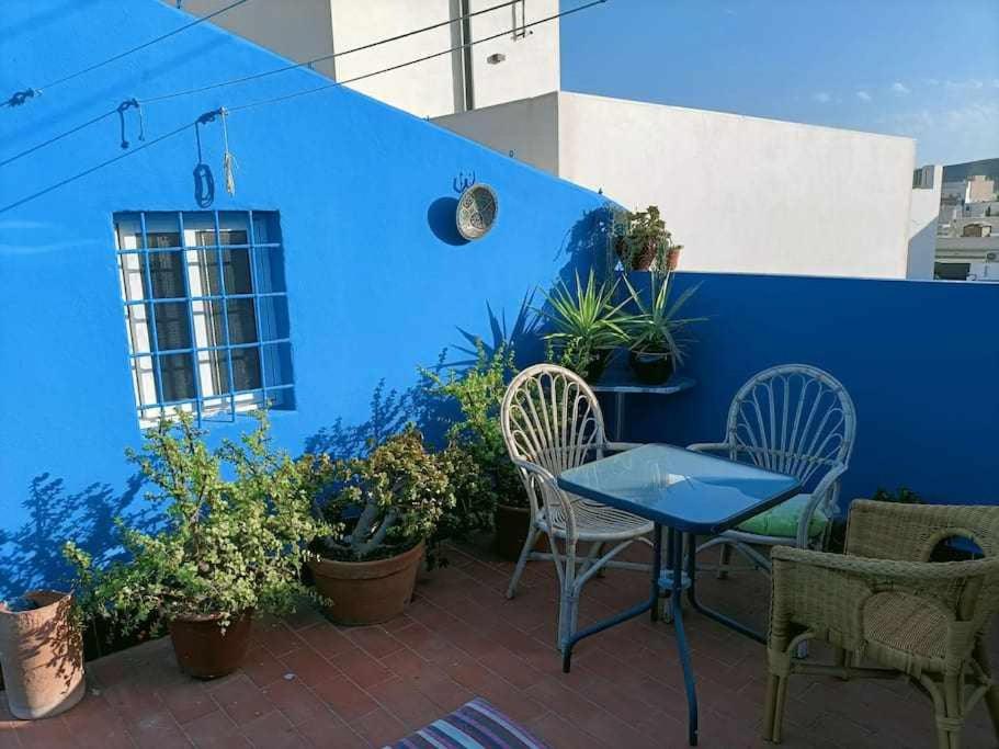 a patio with a blue wall and a table and chairs at Casa de pueblo in Carboneras