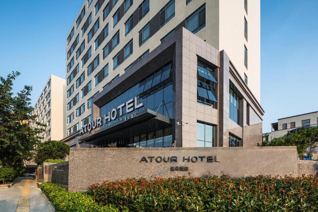 una señal de hotel frente a un edificio en Atour Hotel Qingdao Fuzhou Road Sakura Town en Qingdao