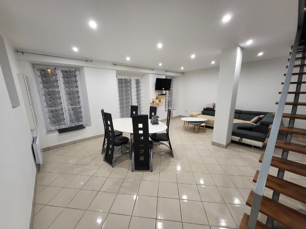 a living room with a table and chairs and a couch at Maison de charme in Benoîtville