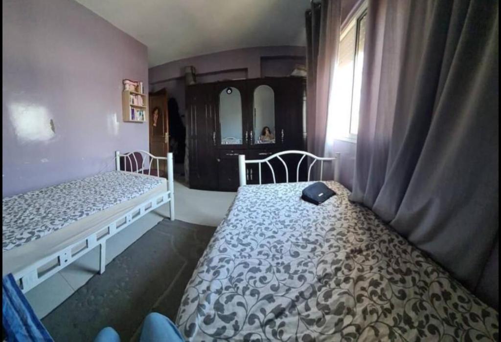 Mansouria的住宿－Maison Maurice，一间卧室设有两张床和窗户。