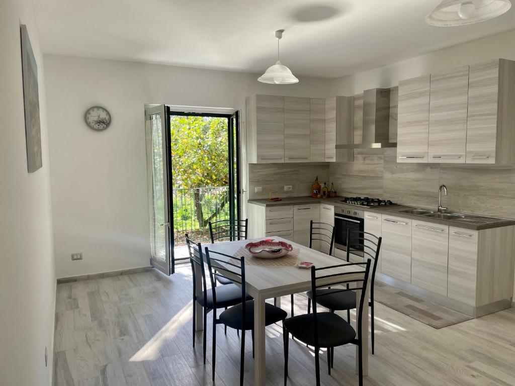 una cucina con tavolo e sedie in una stanza di Sorrento Realty Holidays - The smile of the sun a Sorrento