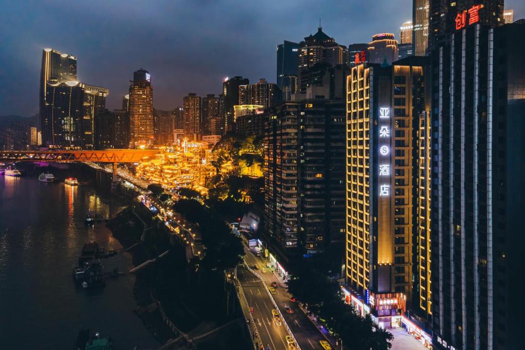 Blick auf eine Stadt in der Nacht mit Gebäuden in der Unterkunft Atour S Hotel Chongqing Jiefangbei Hongyadong Riverview in Chongqing