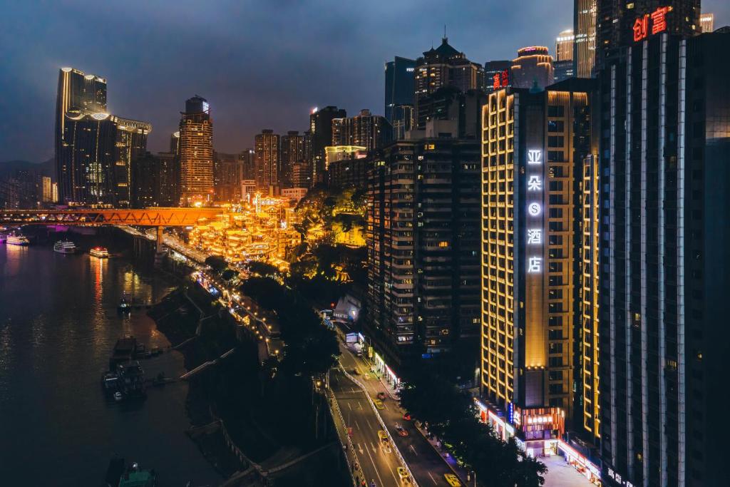 widok na miasto w nocy z budynkami w obiekcie Atour S Hotel Chongqing Jiefangbei Hongyadong Riverview w mieście Chongqing