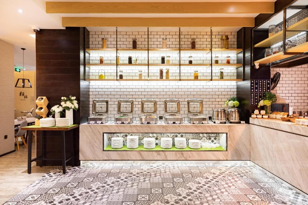 a kitchen with a counter with jars on the wall at Atour Hotel Shanghai Lujiazui Babaihan in Shanghai