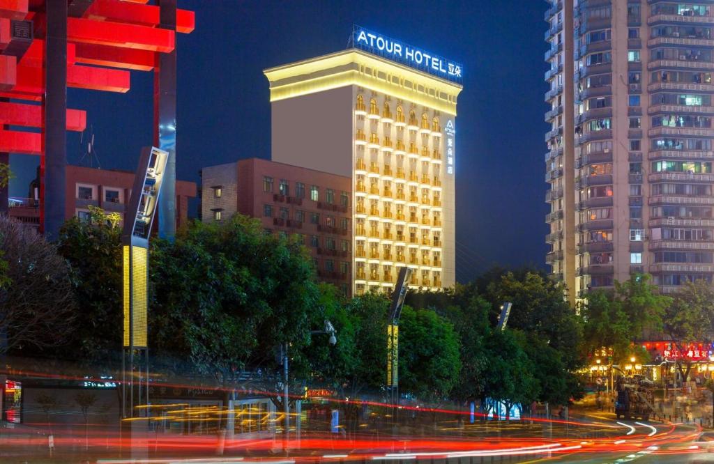 een gebouw met 's nachts een bord erop bij Atour Hotel Chongqing Hongyadong Riverview in Chongqing