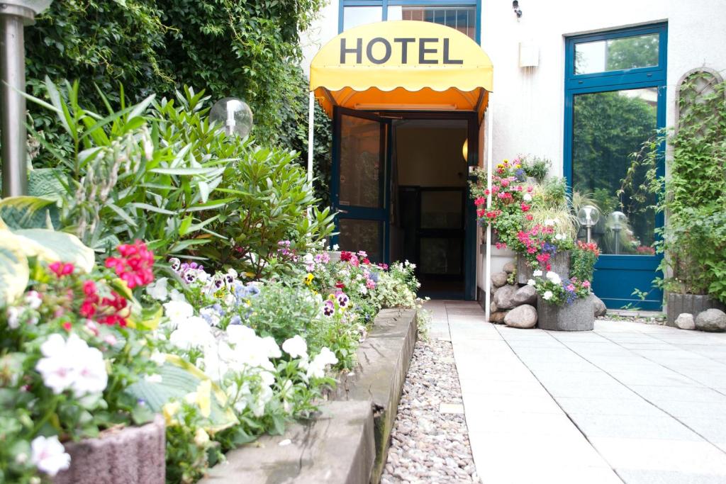 a hotel with flowers in front of a building at Cabo Nonsmoking-Hotel  in Hamburg