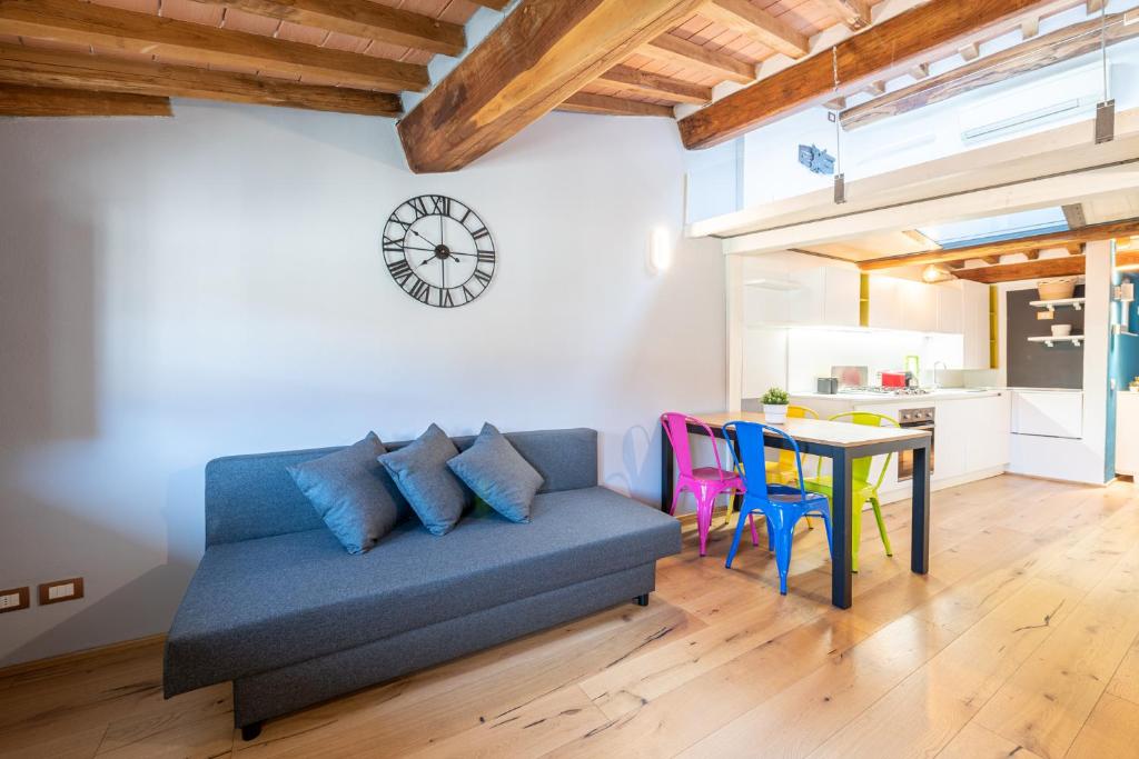 een woonkamer met een blauwe bank en een tafel bij CASA SAN PAOLINO [Dentro le mura]Elegant Flat WIFI e SelfCheckin in Lucca