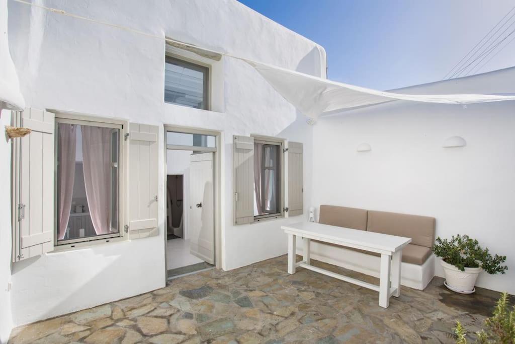 a white house with a white table and windows at Hidden Gem Authentic cycladic house in Paros in Márpissa