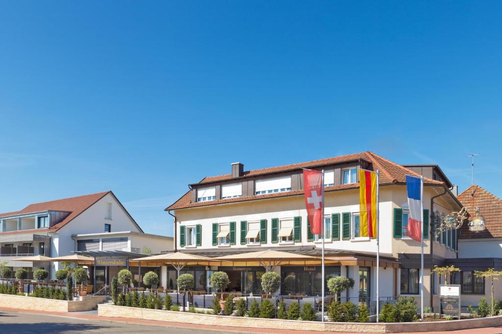 a building with flags in front of it at Hotel Winzerstube in Ihringen