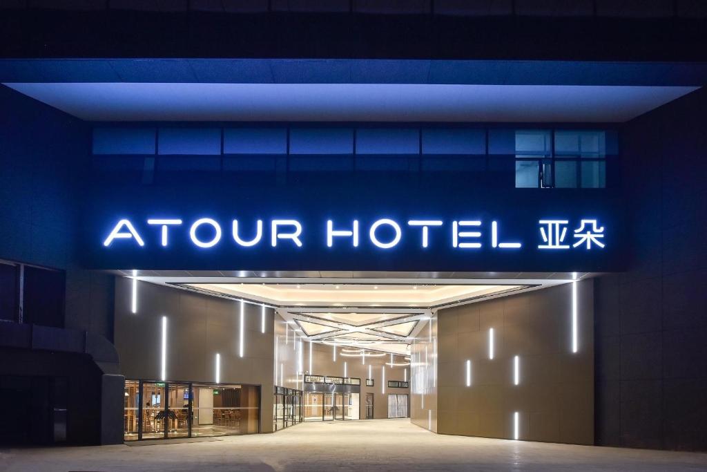 um sinal para um hotel no centro da cidade à noite em Atour Hotel Beijing Fuxingmen em Pequim