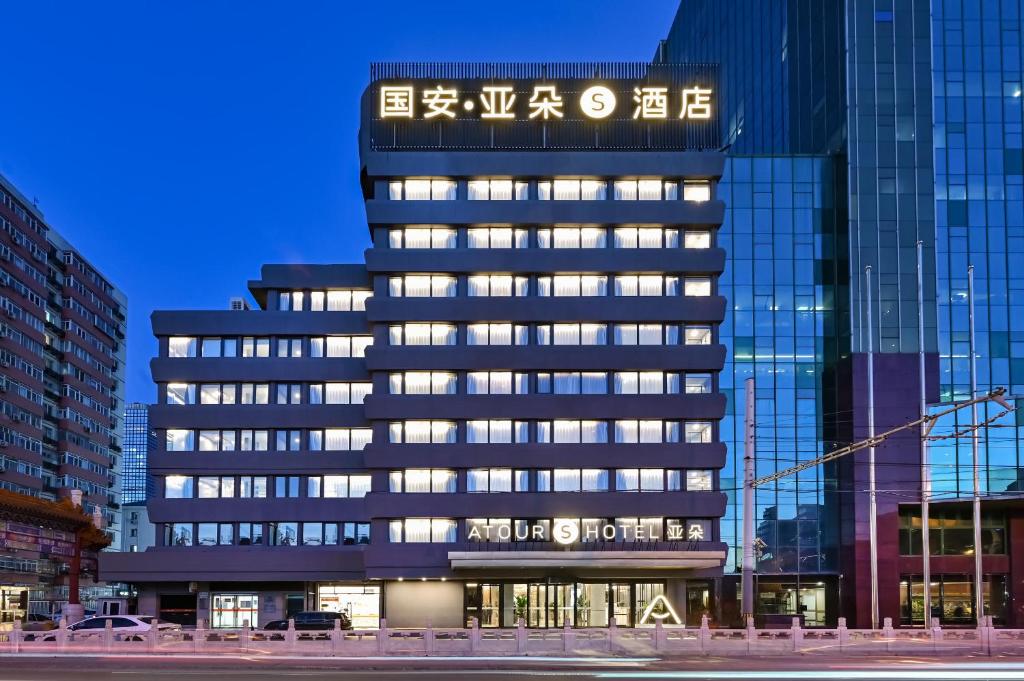 un edificio alto con un cartel asiático en Atour S Hotel Beijing Sanlitun Guoan, en Beijing
