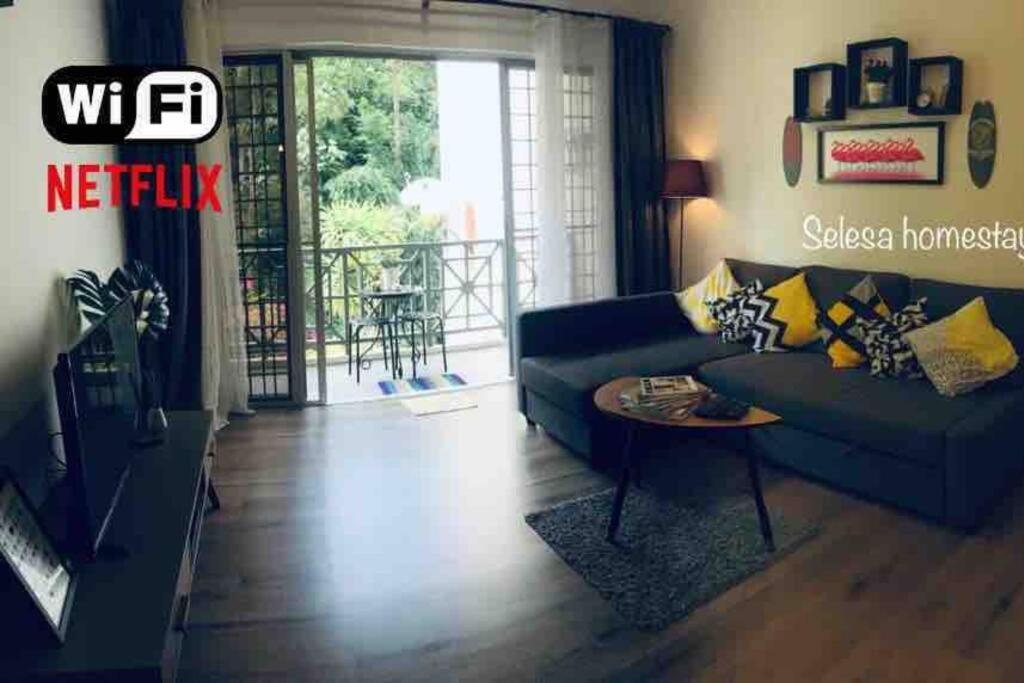 uma sala de estar com um sofá e uma mesa em THAT SPACE@SELESA HILLHOMES, BUKIT TINGGI BENTONG em Bentong