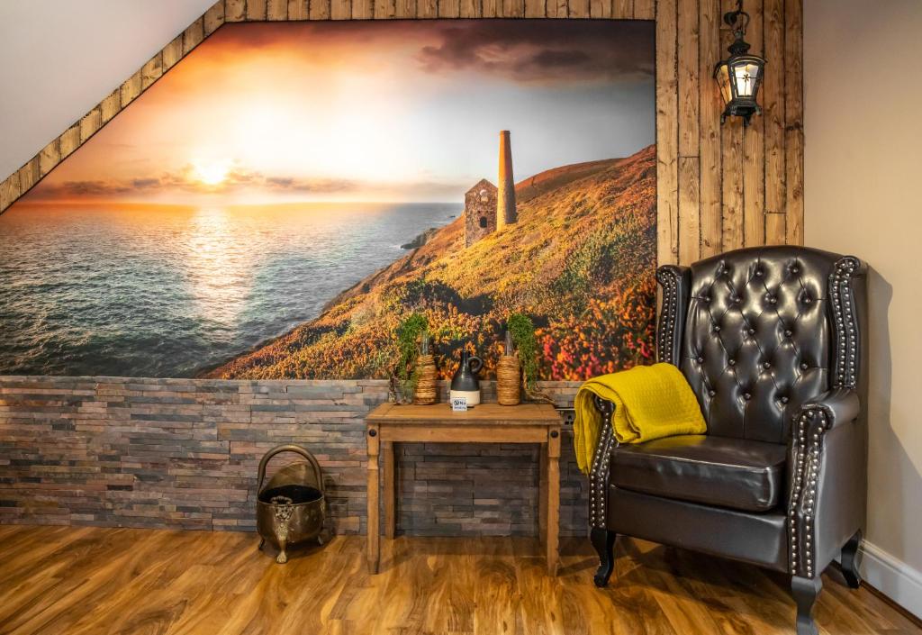ein Wohnzimmer mit einem Wandbild eines Leuchtturms in der Unterkunft Cornish Tin Mine Themed Apartment in St Austell