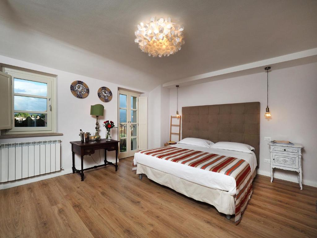 a bedroom with a large bed and a chandelier at CorteViva Boutique B&B in Perugia