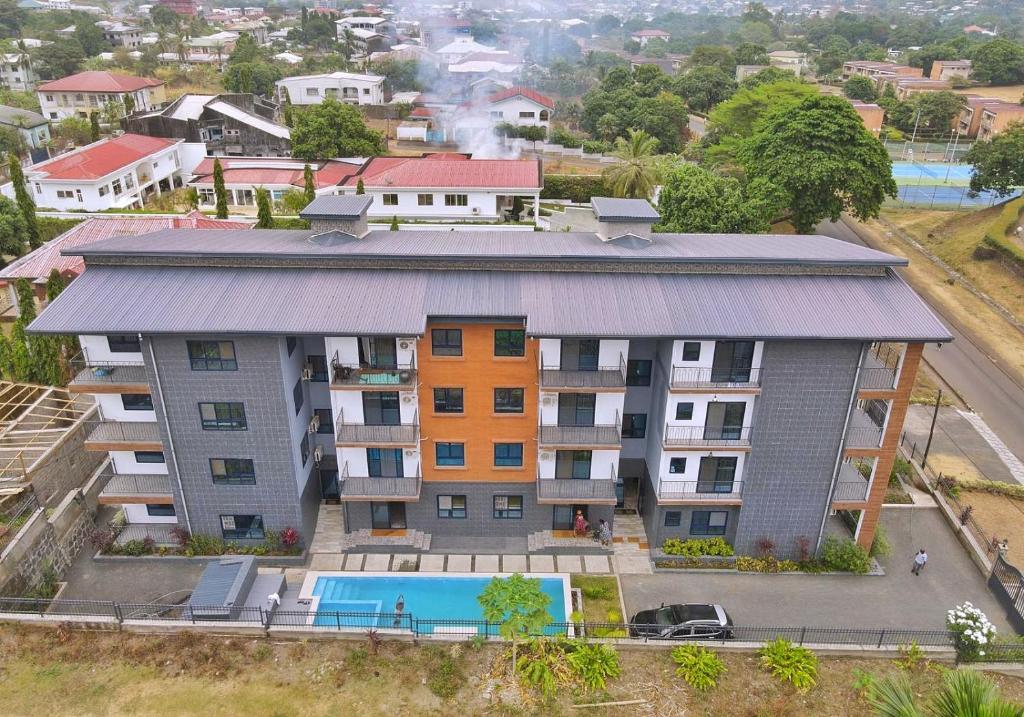 una vista aérea de un edificio de apartamentos con piscina en Candide Guest House en Limbe