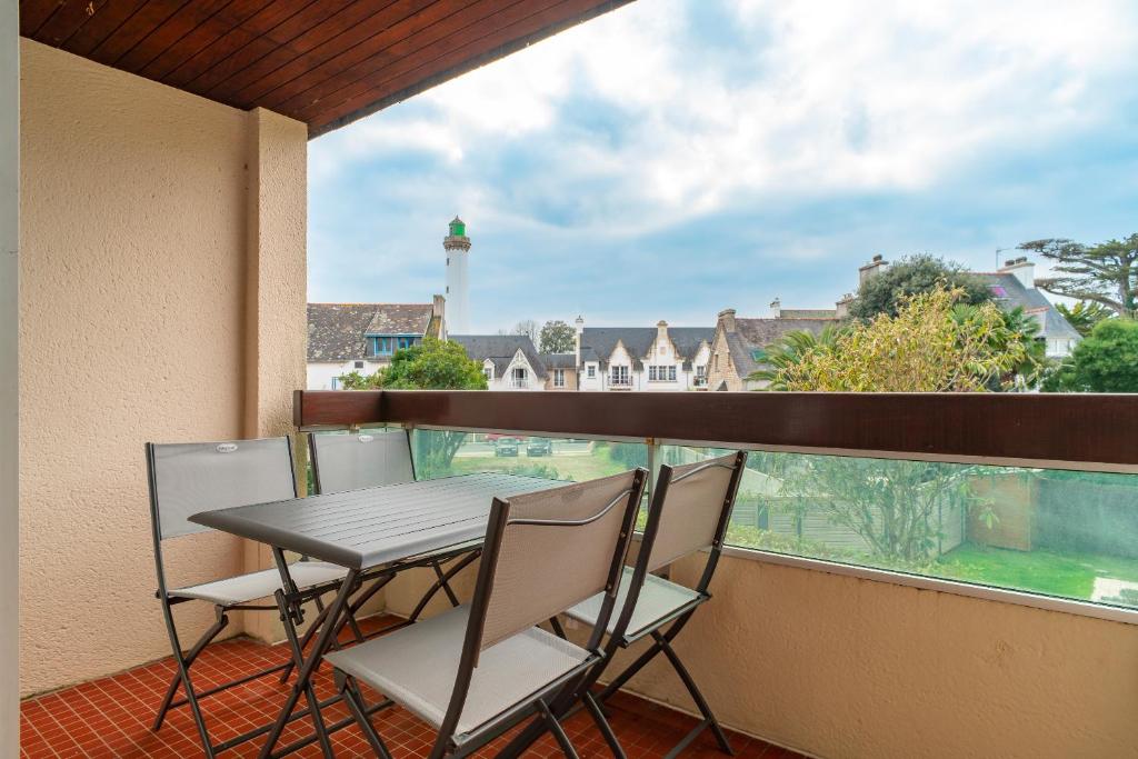 a balcony with a table and chairs and a lighthouse at Ty Menez - Proche plage pour 4 in Bénodet