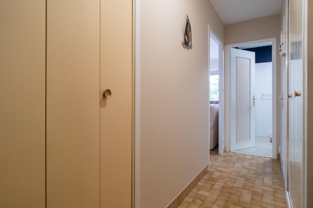 a hallway with white cabinets and a hallway with a door at Ty Menez - Proche plage pour 4 in Bénodet