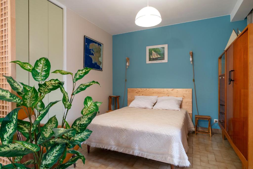 a bedroom with a bed and a plant at Ty Menez - Proche plage pour 4 in Bénodet