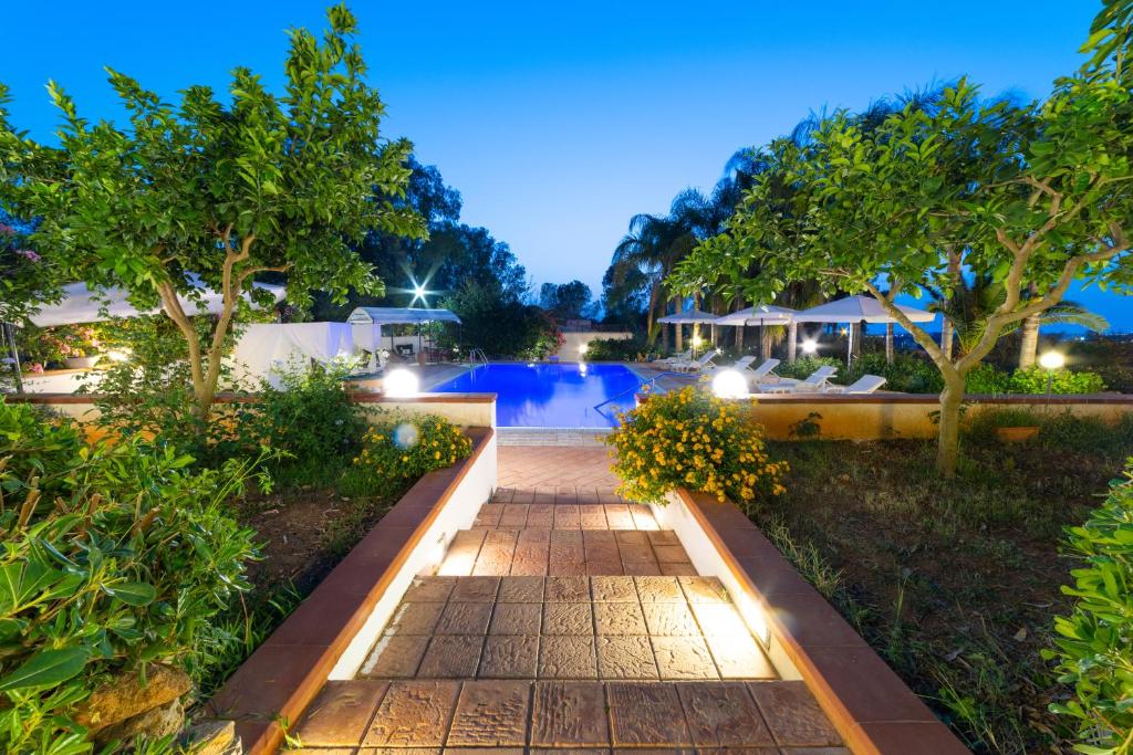 a walkway leading to a pool at night at Villa Rosemary in Marsala