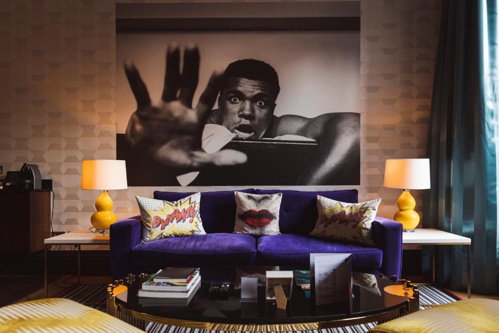 a living room with a purple couch and a poster of a man at The Rutland Hotel & Apartments in Edinburgh