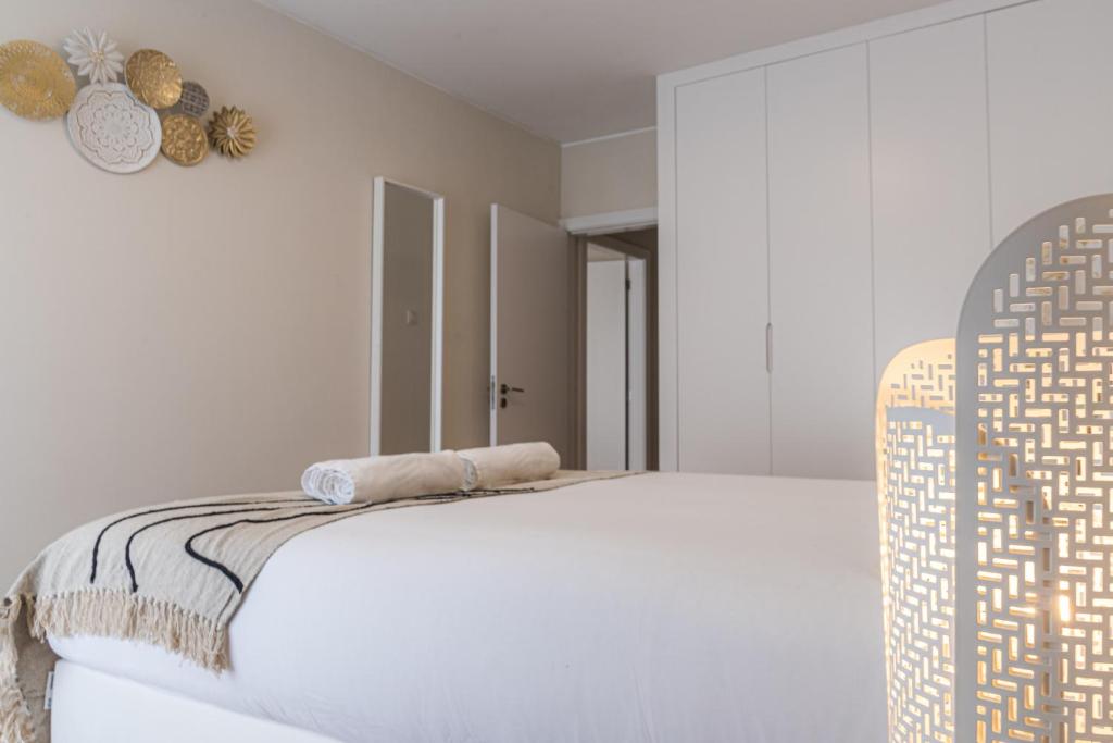 een witte slaapkamer met een bed met een hoofdeinde bij Modern Pilar Apartment by Homing in Vila Nova de Gaia