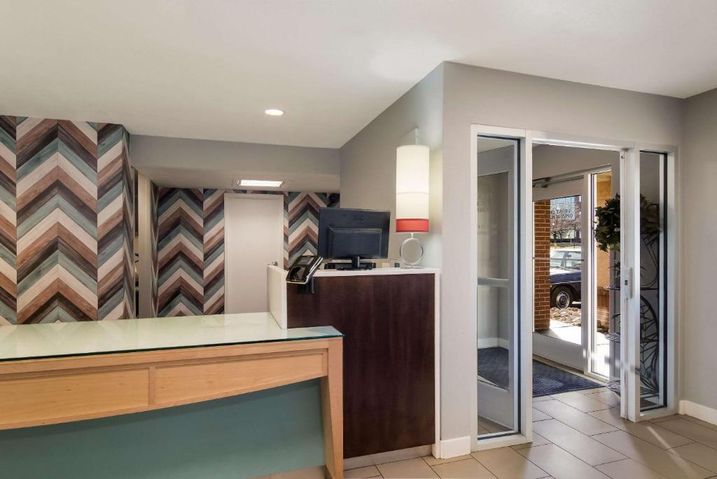 an office with a desk with a tv and a mirror at MainStay Suites Omaha Old Mill in Omaha