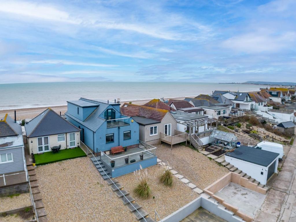 a group of houses on the beach next to the ocean at Beach View Breeze Family Holiday Home on the Shore in Pevensey