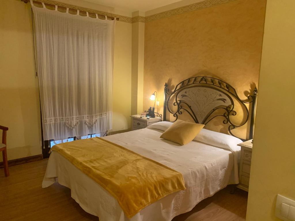 La Concha的住宿－posada carral cabarceno，一间卧室设有一张大床和一个窗户。