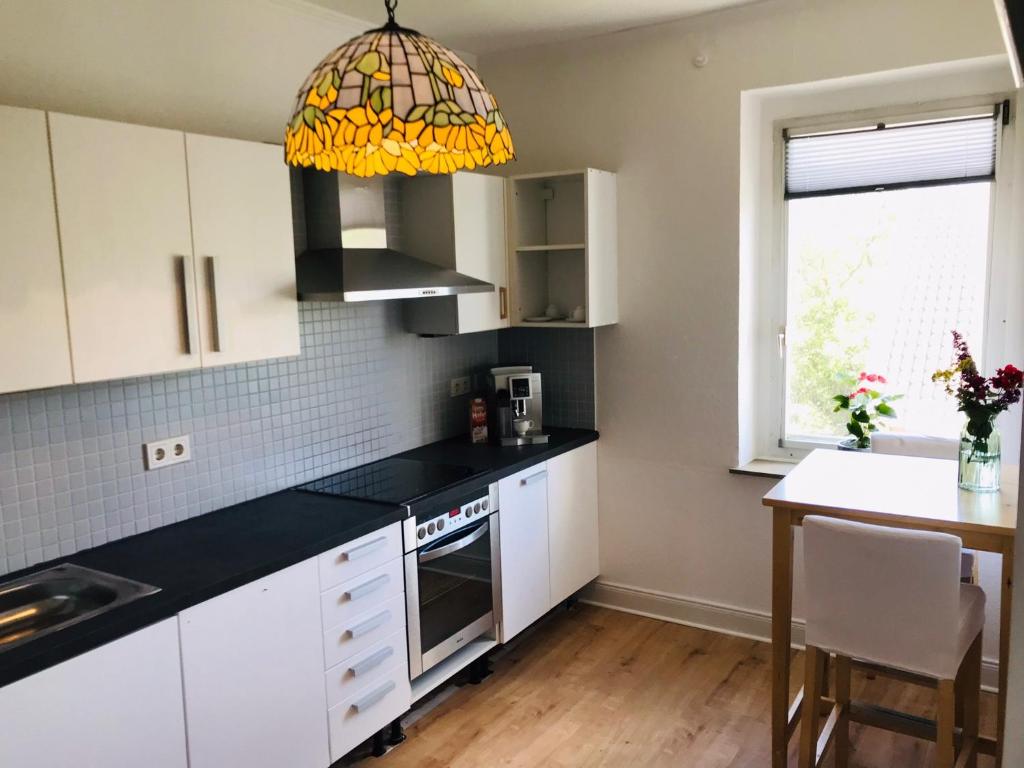 トロイスドルフにあるTroisdorf - City - 64Qm - 1 bis 3 Schlafplätzeの白いキャビネットと黒いカウンタートップを備えたキッチン