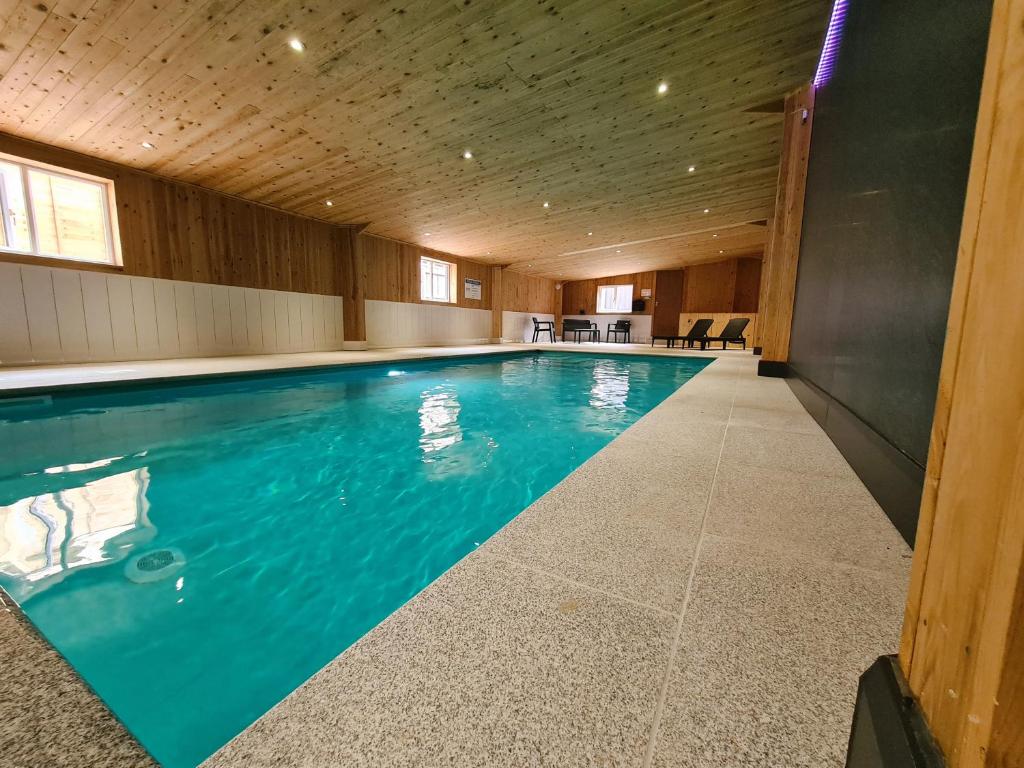 a swimming pool in a building with a wooden ceiling at Twitchill Farm Cottages, Indoor Heated Pool, Peak District in Hope