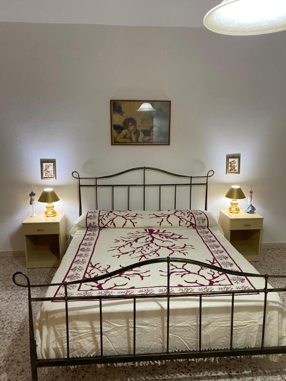 um quarto com uma cama com duas mesas de cabeceira em A cà da Nonnina em Carloforte