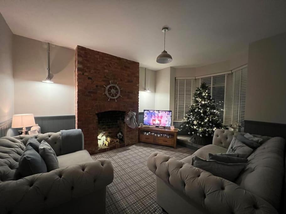 a living room with a couch and a christmas tree at The Boathouse - Hottub - Sleeps 6 in Woodhorn