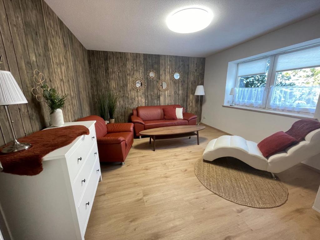 un soggiorno con un divano e un tavolo di Ferienwohnung „Haus Herbert“ Wohnung „Emma“ a Langsdorf