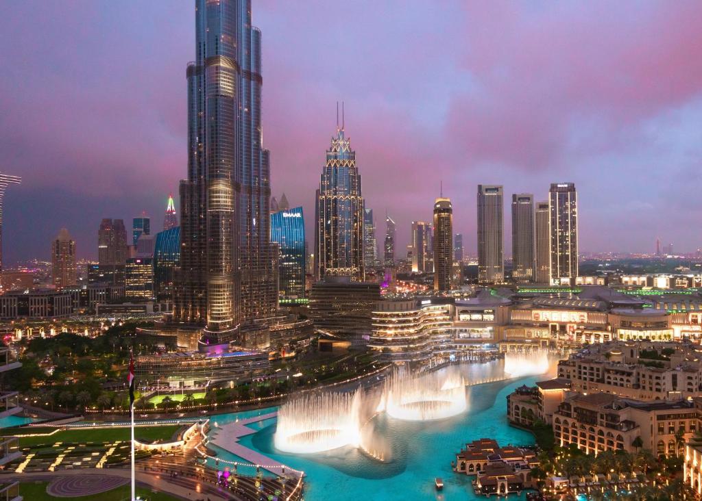 uma vista da cidade à noite com uma fonte em Elite Royal Apartment - Burj Residences T5 | Diamond em Dubai