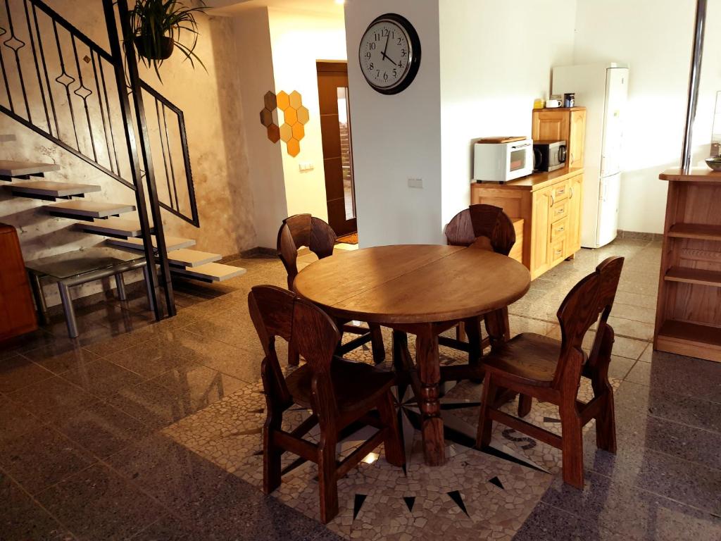 comedor con mesa, sillas y reloj en Keturių kambarių namas,Vilnius, en Riešė