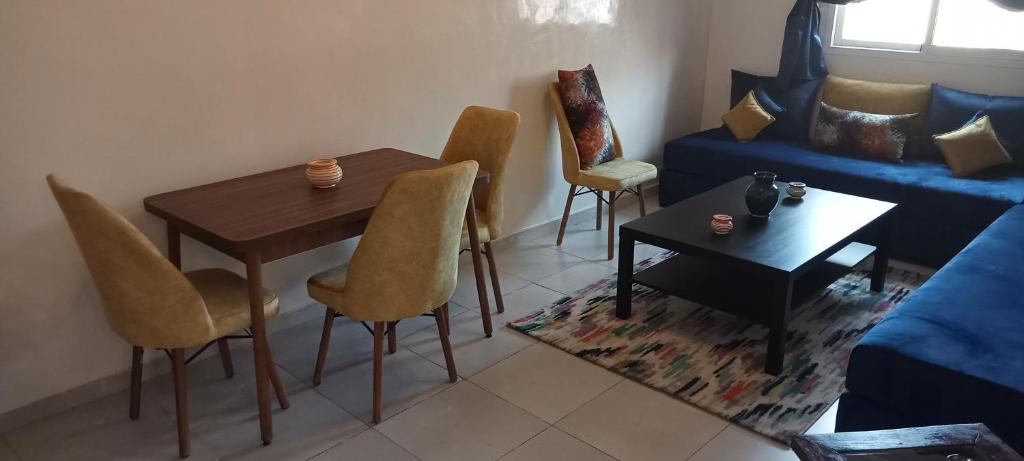 uma sala de estar com uma mesa e cadeiras e um sofá em Dyour marjan em Marrakech