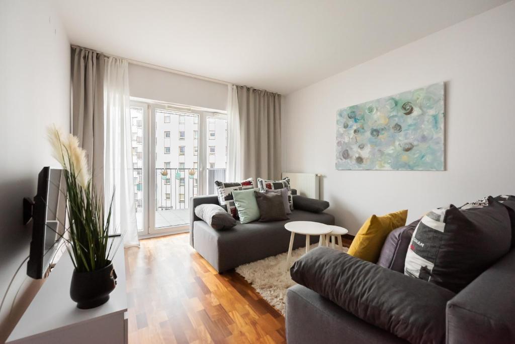 a living room with a couch and a table at Wola Sunset Apartment FREE Parking in Warsaw