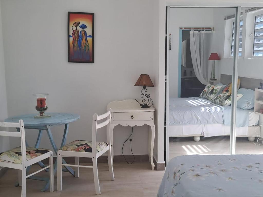 a bedroom with a table and a bed and a mirror at Tropical in Orient Bay French St Martin