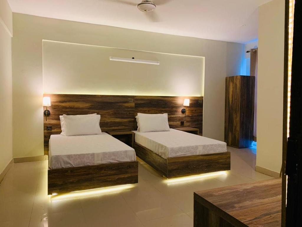 sypialnia z 2 łóżkami i dużym lustrem w obiekcie TULIP HOTELS AND APPARTMENTS w mieście Karaczi