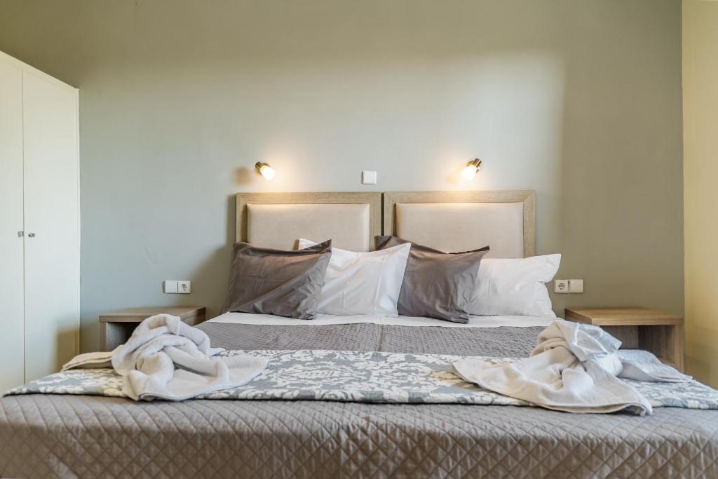 Una cama con sábanas blancas y almohadas en un dormitorio en Blue Lagoon, en Amoudi