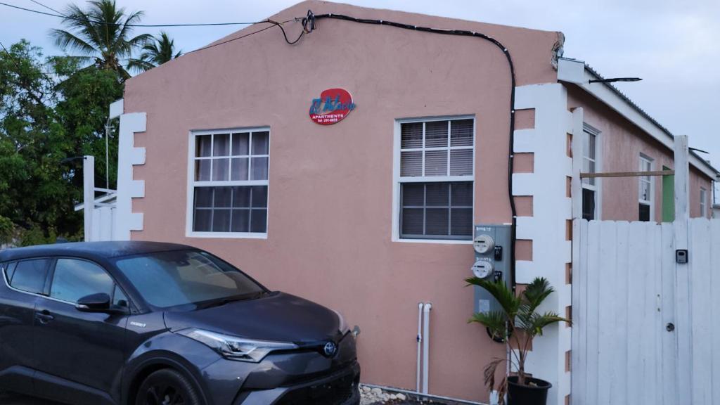 een zwarte auto geparkeerd voor een roze gebouw bij El Palacio Hidden City Place #2 in Bridgetown