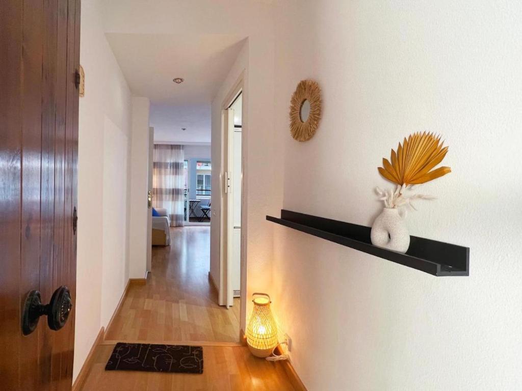 een hal met een witte muur met planken en een lamp bij Hauzify I Apartament Can Reig in San Pol de Mar