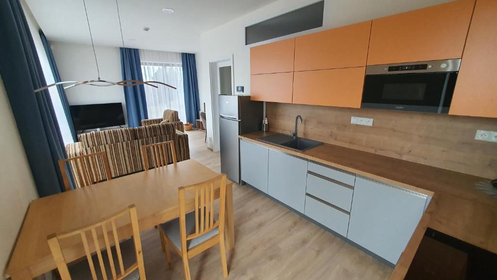 a kitchen with a table and chairs and a kitchen with a sink at Apartmány Semily in Semily